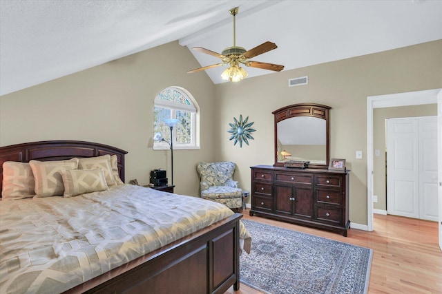 bedroom featuring a ceiling fan, visible vents, baseboards, lofted ceiling with beams, and light wood finished floors