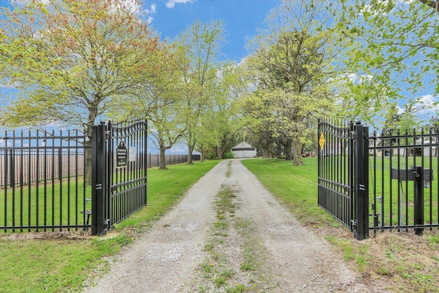 view of street with driveway, a gated entry, and a gate