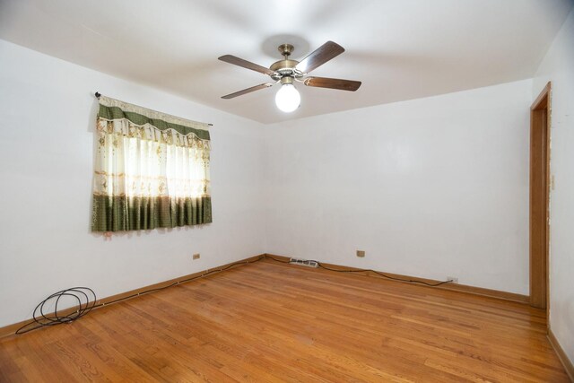 17246 Bernadine St, Lansing, IL 60438 - empty room featuring light wood-style floors, a ceiling fan, and baseboards
