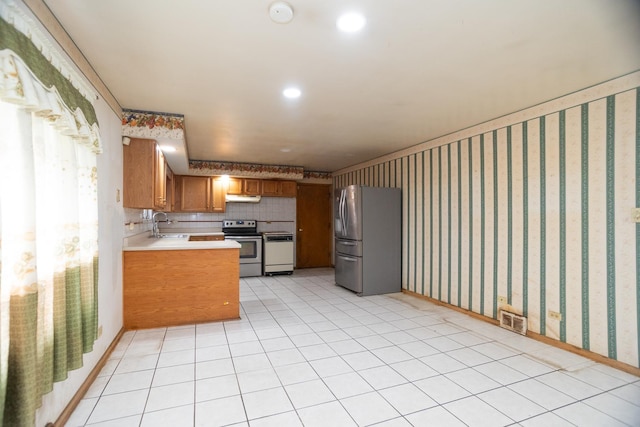 17246 Bernadine St, Lansing, IL 60438 - kitchen with brown cabinets, visible vents, stainless steel appliances, light countertops, and wallpapered walls