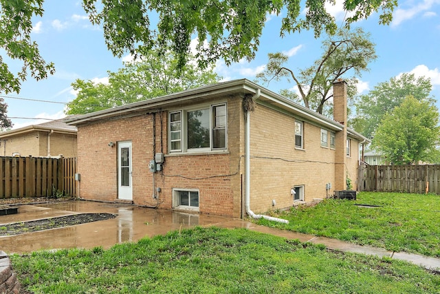15058 Tripp Ave, Midlothian, IL 60445 - view of side of property with brick siding, a chimney, and a patio
