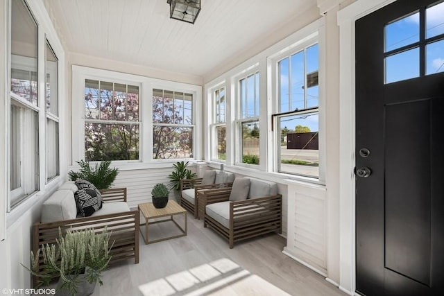 sunroom / solarium with a healthy amount of sunlight and wood finished floors