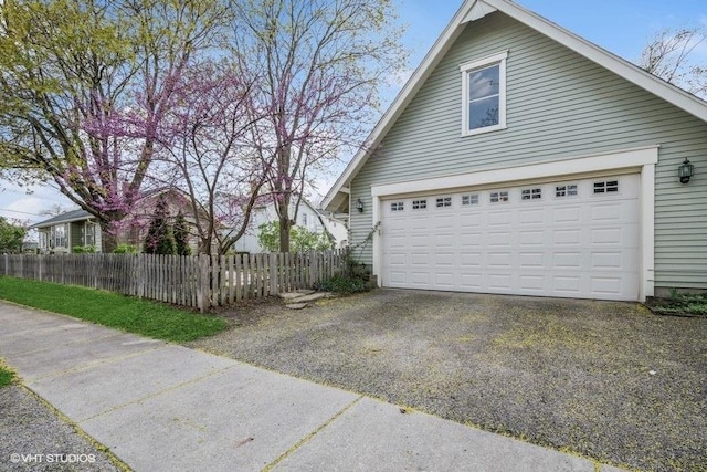 view of side of home with a garage and fence