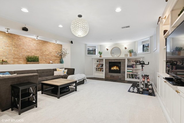 living area featuring visible vents, brick wall, baseboards, recessed lighting, and a tiled fireplace