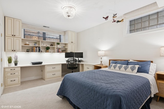 bedroom featuring built in study area, baseboards, visible vents, and light carpet