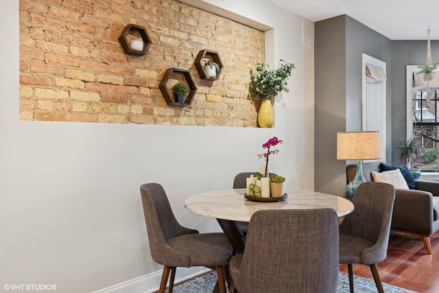 dining space with baseboards and wood finished floors