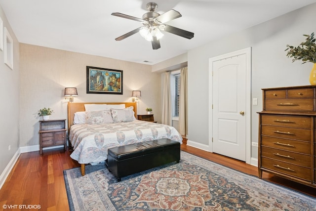 bedroom featuring baseboards, ceiling fan, wood finished floors, and visible vents