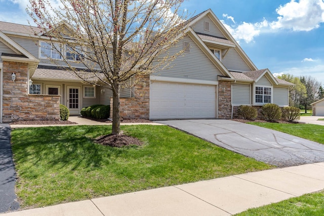 1103 Shingle Oak Ln Unit 3A, Rockford, IL 61107 - view of front of house with stone siding, driveway, roof with shingles, a front lawn, and an attached garage