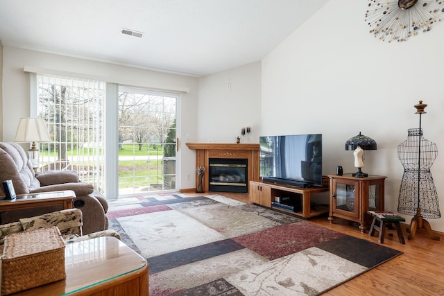 1103 Shingle Oak Ln Unit 3A, Rockford, IL 61107 - living area featuring lofted ceiling, visible vents, a fireplace with flush hearth, and wood finished floors
