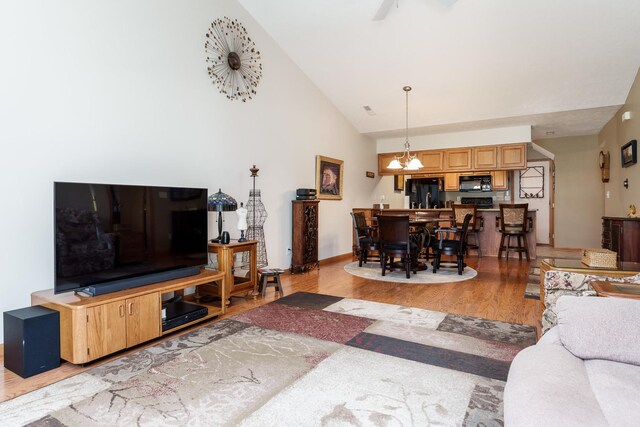 1103 Shingle Oak Ln Unit 3A, Rockford, IL 61107 - living area featuring a notable chandelier, high vaulted ceiling, baseboards, and light wood-type flooring