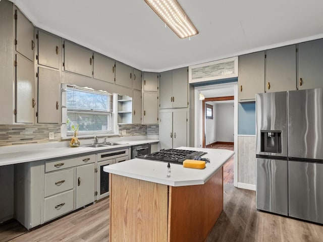 kitchen with gas cooktop, stainless steel fridge, gray cabinets, and wood finished floors