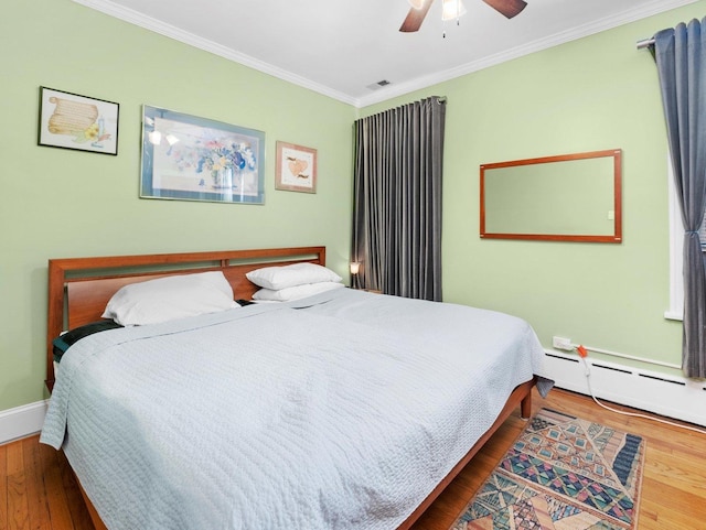 3924 W 64th Pl, Chicago, IL 60629 - bedroom with crown molding, wood finished floors, a baseboard radiator, a ceiling fan, and baseboards