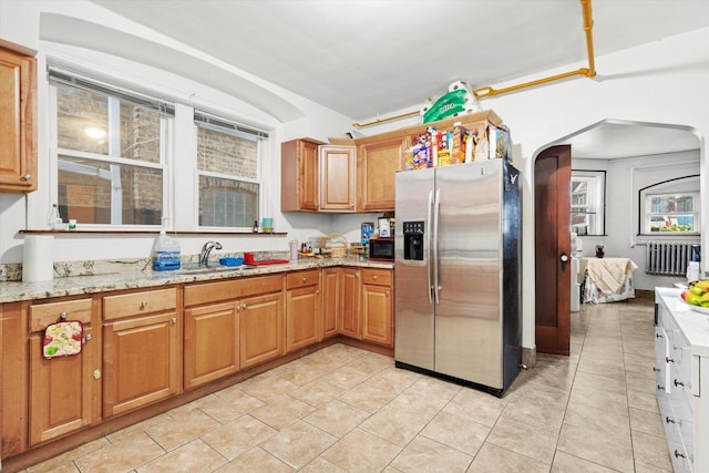 3924 W 64th Pl, Chicago, IL 60629 - kitchen featuring stainless steel refrigerator with ice dispenser, a sink, arched walkways, radiator, and light stone countertops