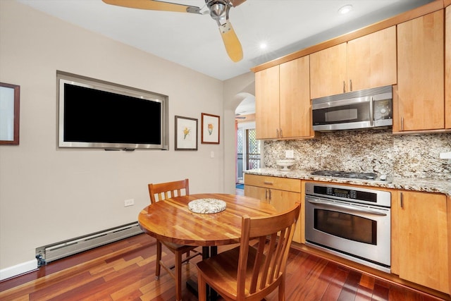3924 W 64th Pl, Chicago, IL 60629 - kitchen featuring stainless steel appliances, a baseboard radiator, arched walkways, a ceiling fan, and dark wood-style flooring