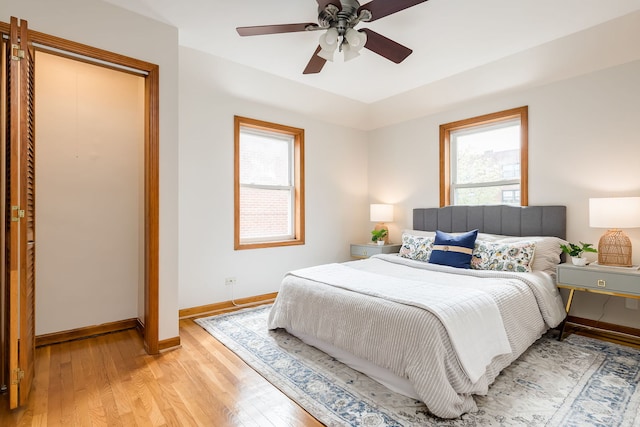bedroom featuring baseboards, light wood finished floors, and ceiling fan