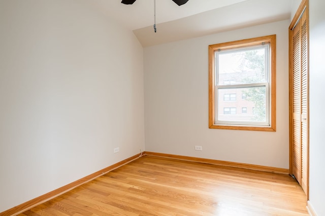 unfurnished bedroom with vaulted ceiling, baseboards, a closet, and light wood-type flooring