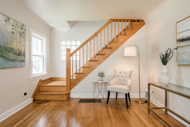 staircase featuring baseboards and wood finished floors