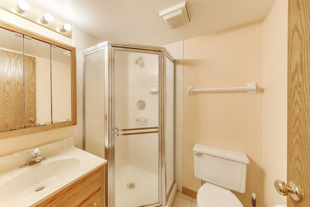 full bathroom with vanity, tile patterned flooring, a stall shower, and toilet