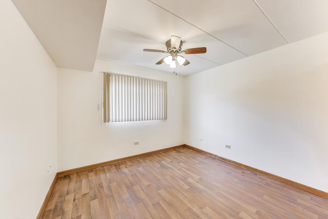 empty room featuring a ceiling fan, baseboards, and light wood-style flooring