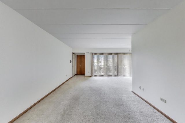 carpeted empty room featuring baseboards
