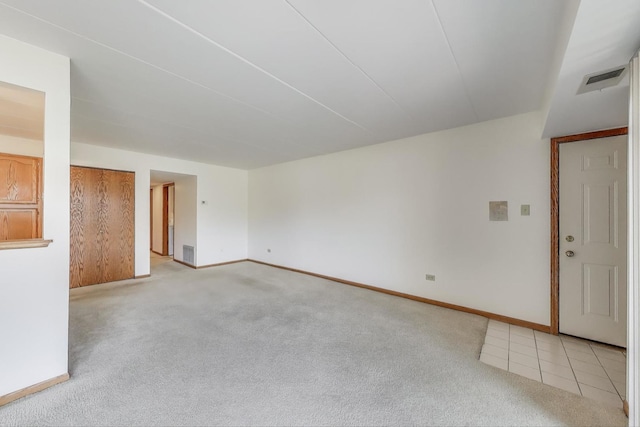 empty room with baseboards, visible vents, and light colored carpet