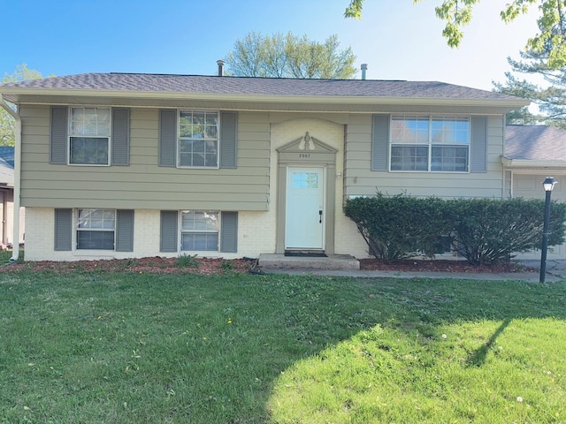 2007 E Vermont Ave, Urbana, IL 61802 - split foyer home with a shingled roof, brick siding, and a front lawn