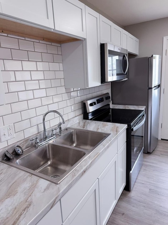 2007 E Vermont Ave, Urbana, IL 61802 - kitchen featuring stainless steel appliances, light countertops, white cabinets, and a sink