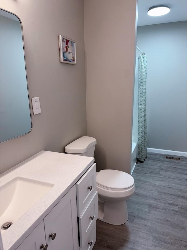 2007 E Vermont Ave, Urbana, IL 61802 - full bathroom featuring wood finished floors, toilet, vanity, baseboards, and visible vents