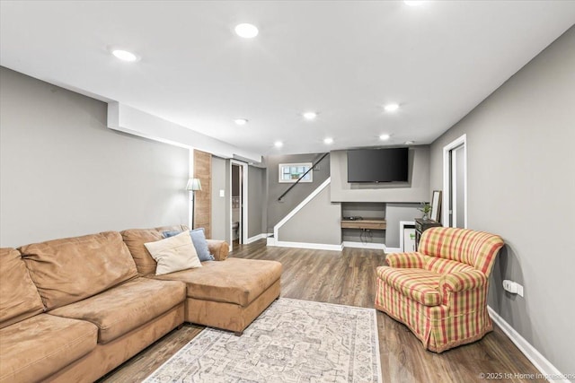 living area featuring baseboards, recessed lighting, stairs, and wood finished floors
