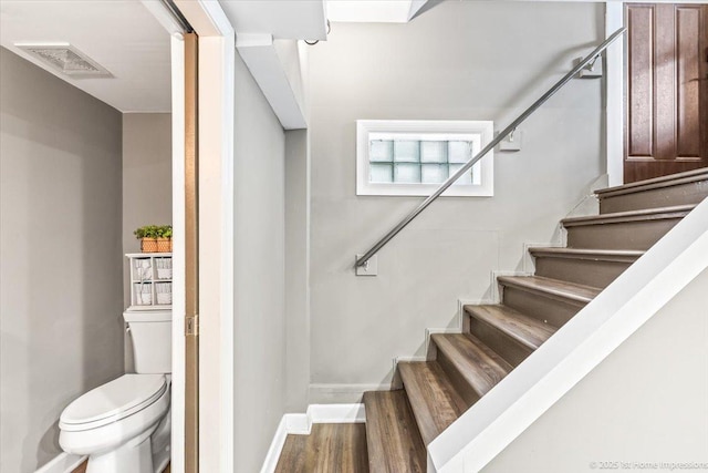 stairs featuring baseboards, visible vents, and wood finished floors