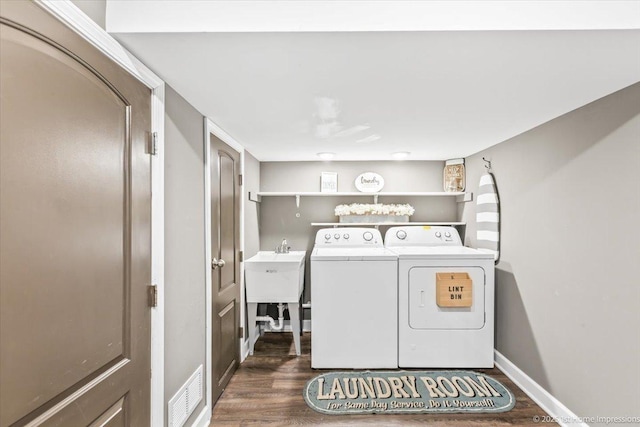 washroom with laundry area, visible vents, dark wood-style flooring, washing machine and dryer, and baseboards