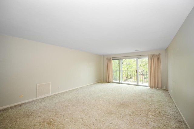 carpeted empty room featuring baseboards and visible vents