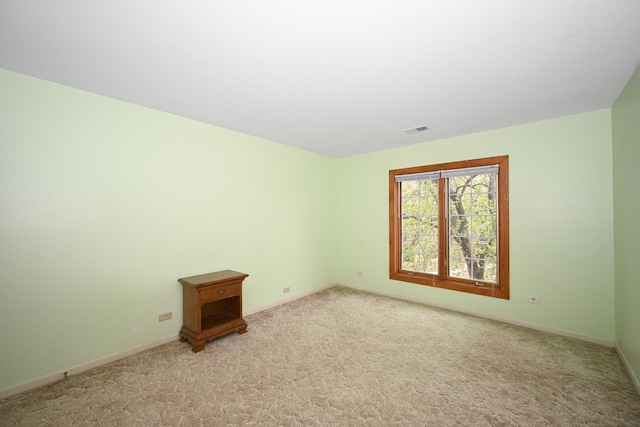 carpeted empty room featuring visible vents and baseboards