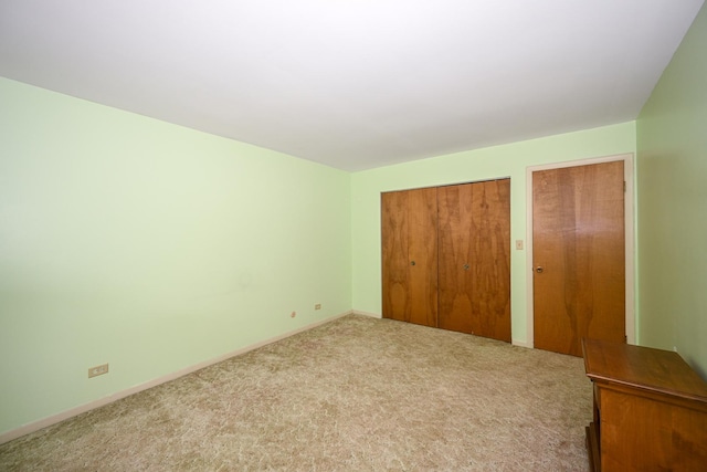 unfurnished bedroom with carpet floors, multiple closets, and baseboards