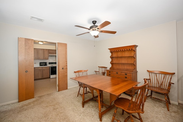 dining area featuring baseboards, ceiling fan, light carpet, and visible vents