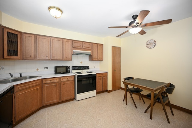kitchen with under cabinet range hood, brown cabinets, tasteful backsplash, a sink, and black appliances