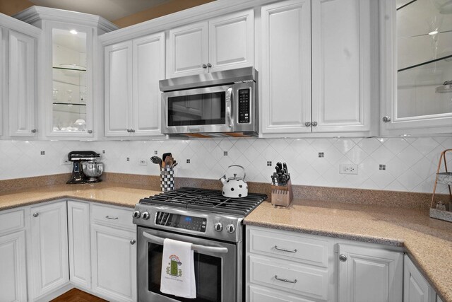 kitchen featuring appliances with stainless steel finishes, white cabinetry, and tasteful backsplash