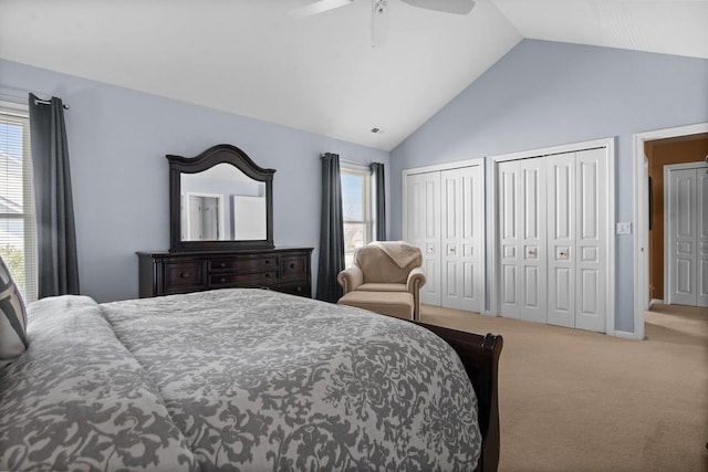 carpeted bedroom featuring ceiling fan, multiple closets, visible vents, and multiple windows