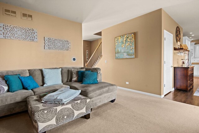living room with recessed lighting, stairs, dark colored carpet, and baseboards