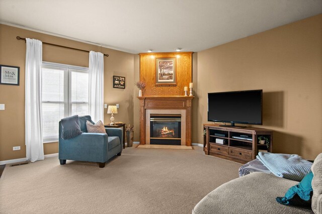 living room with baseboards, visible vents, a fireplace with flush hearth, and carpet