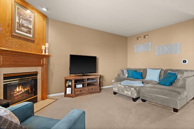 carpeted living area with visible vents, a high end fireplace, and baseboards