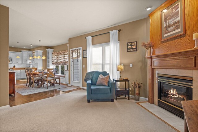 living room featuring a tile fireplace, light colored carpet, and recessed lighting