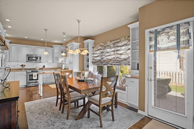 dining area featuring recessed lighting, an inviting chandelier, and dark wood-type flooring