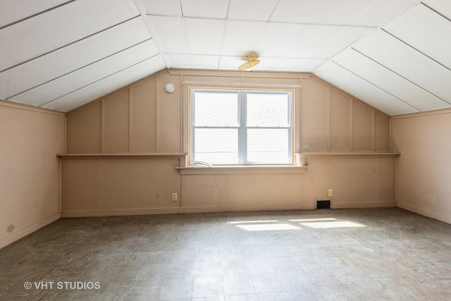 additional living space featuring baseboards and vaulted ceiling