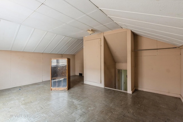 bonus room with baseboards and vaulted ceiling