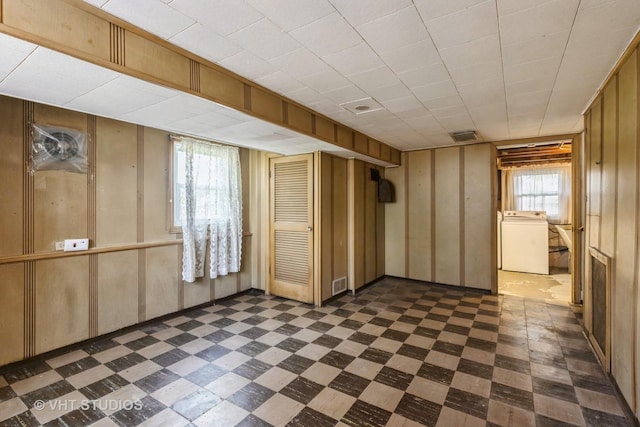 basement with washer / dryer, dark floors, and visible vents