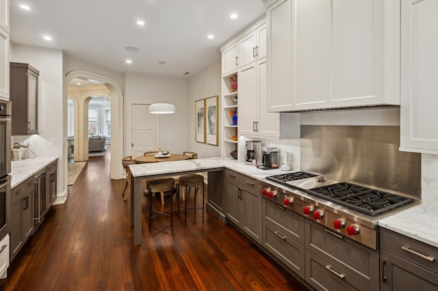 1242 N Astor St, Chicago, IL 60610 - kitchen with stainless steel gas cooktop, dark wood finished floors, arched walkways, tasteful backsplash, and recessed lighting