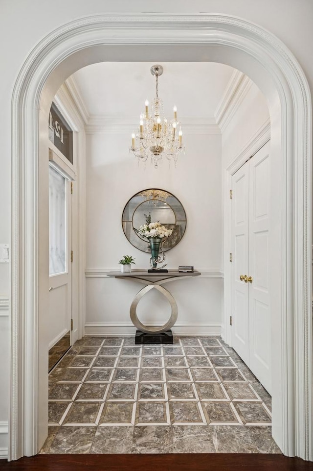 1242 N Astor St, Chicago, IL 60610 - foyer entrance featuring arched walkways, a notable chandelier, and ornamental molding