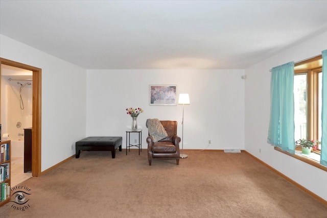 sitting room featuring light carpet and baseboards