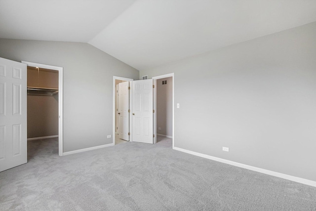 1005 Thomas Blvd, Mundelein, IL 60060 - unfurnished bedroom with visible vents, baseboards, a walk in closet, carpet flooring, and vaulted ceiling